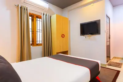 a bedroom with a bed and a flat screen tv at Collection O Marhaba Govindapuram in Calicut