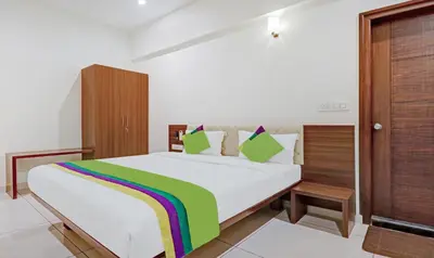 a bedroom with a white bed with a colorful blanket at Treebo RJ Residency in Mysore