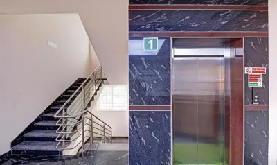 a staircase in a building with a metal elevator at Treebo RJ Residency in Mysore