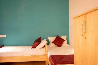 a bedroom with two bunk beds and a blue wall at Roambay in Mysore