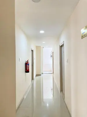 a hallway with white walls and a fire extinguisher on the wall at The INN in Mysore