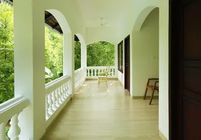 a hallway of a house with white walls and wood floors at Once Upon The River, Aluva - Near Cochin International Airport in Cochin