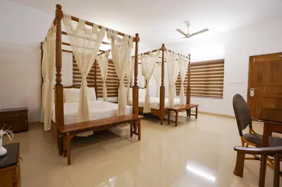 a bedroom with three beds with mosquito nets at Once Upon The River, Aluva - Near Cochin International Airport in Cochin