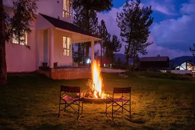 two chairs sitting around a fire in a yard at Villa Sullivan by VEO - Part of StayVista in Ooty