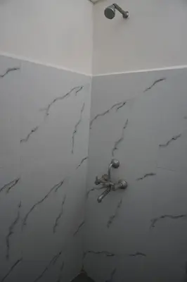 a bathroom with a marble shower with a sink at Cornerbunker in Mysore