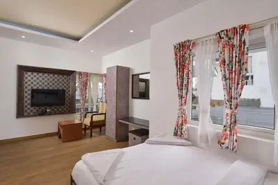 a bedroom with a bed and a large window at Villa Hugel ooty By StayVista in Ooty
