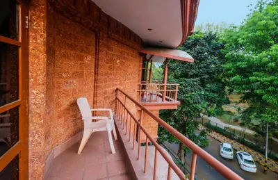 a white chair sitting on the balcony of a building at Parklane Hotel in Mysore