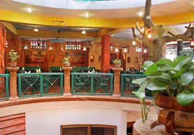a restaurant with a green railing in a building at Parklane Hotel in Mysore