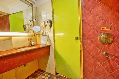 a bathroom with a green shower door and a sink at Parklane Hotel in Mysore