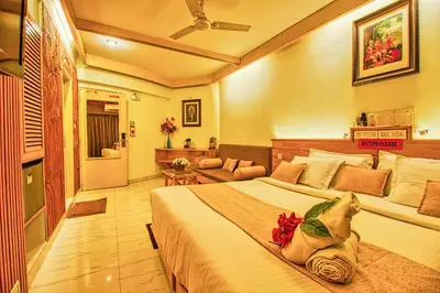 a bedroom with a large bed and a couch at Parklane Hotel in Mysore