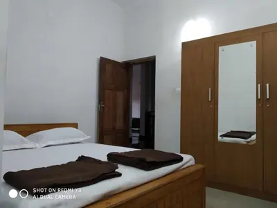 a bedroom with a bed with two brown towels on it at Ammu's home stay in Panamaram