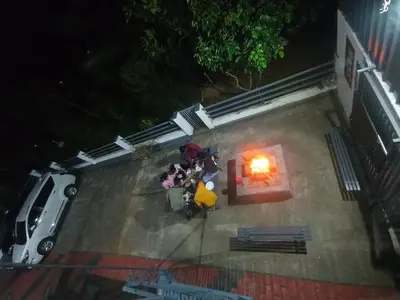 an overhead view of a group of people sitting around a fire at Ammu's home stay in Panamaram