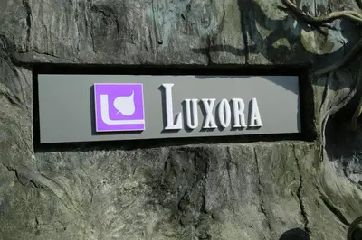 a sign on the side of a stone wall at Luxora Hotel and Spa in Kozhikode