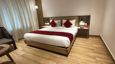 a hotel room with a large bed with red pillows at GAYATHRI HOTELS in Badagara