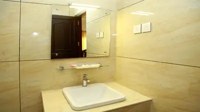 a bathroom with a sink and a mirror at GAYATHRI HOTELS in Badagara