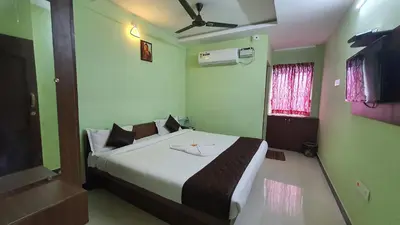 a bedroom with a large bed with green walls at JR Guest Home in Coimbatore