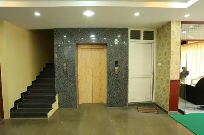 a lobby with a wooden door and stairs at JR Guest Home in Coimbatore