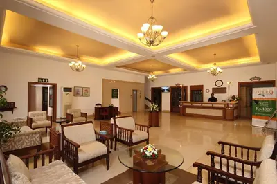a lobby with chairs and tables in a building at Hotel CLOUD 9 in Kotamangalam
