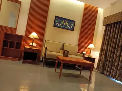 a waiting room with two chairs and a table and a mirror at Hotel CLOUD 9 in Kotamangalam