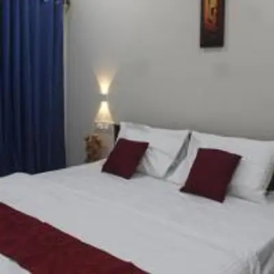 a bedroom with a white bed with red pillows at Nature Villa Kochi in Alwaye