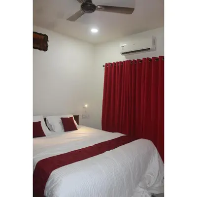 a bedroom with a bed with a red curtain at Nature Villa Kochi in Alwaye