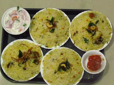 a black tray with five cups of food on it at Green Garden Lotus in Vythiri