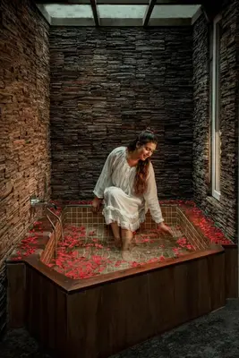 a woman in a bath tub filled with red roses at Kuruva Island Resort And Spa - By KABINI BREEZE in Mananthavady