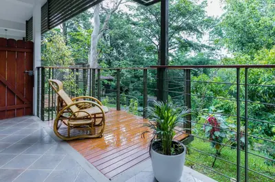 a screened in porch with a chair and a plant at Kuruva Island Resort And Spa - By KABINI BREEZE in Mananthavady