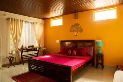 a bedroom with a large red bed in a room at Siddhi Aloha in Madikeri