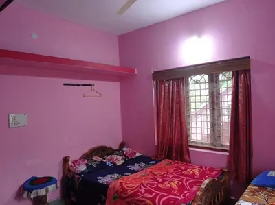 a bedroom with a bed and a window with pink walls at Dreams River view Homestay Coorg in Kushālnagar