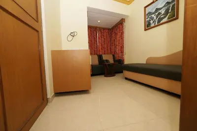 a room with a bedroom with a bed and a chair at Hotel Nahar Manchester Inn in Coimbatore