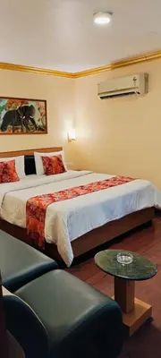 a hotel room with a bed and a table at Hotel Nahar Manchester Inn in Coimbatore