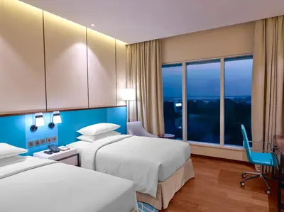 a hotel room with two beds and a window at Hyatt Regency Thrissur in Trichūr