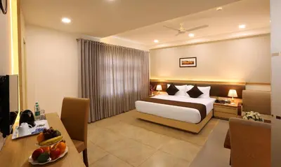a hotel room with a bed and a table at Flora Charishma Residency Aluva in Cochin