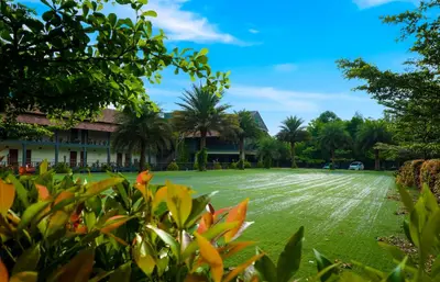 a large lawn in front of a building at Fern Tree Resort in Mananthavady