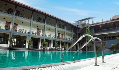 a swimming pool in front of a building at Fern Tree Resort in Mananthavady