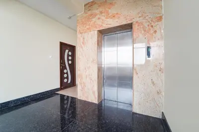 a metal elevator in a room with a wall at FabHotel Manis Residency in Coimbatore