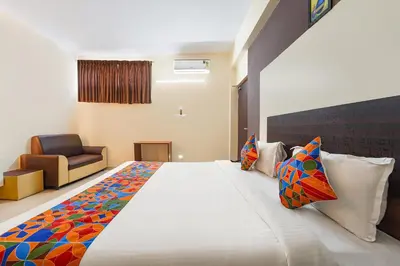 a bedroom with a large white bed with colorful pillows at FabHotel Manis Residency in Coimbatore