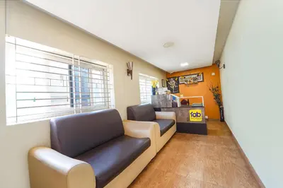 a living room with a couch and a window at FabHotel Manis Residency in Coimbatore