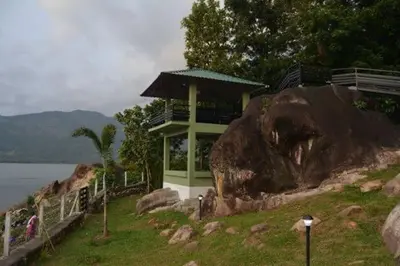a house on a hill next to a large rock at Diga vista resorts in Palakkad