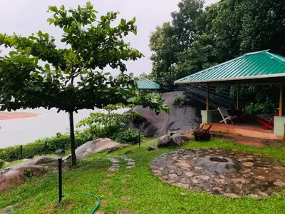 a garden with a fire pit and a house at Diga vista resorts in Palakkad