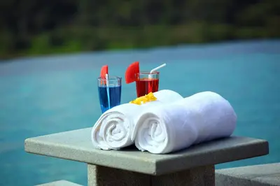 a towel and two drinks sitting on a table at Arayal Resort-A Unit of Sharoy Resort in Tariyod
