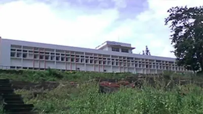 a large white building on a hill with stairs at KTDC Garden House in Palakkad