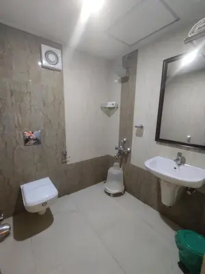 a bathroom with a sink and a toilet and a mirror at KTDC Garden House in Palakkad