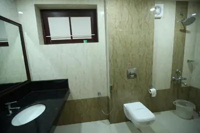 a bathroom with a sink and a toilet and a window at KTDC Garden House in Palakkad