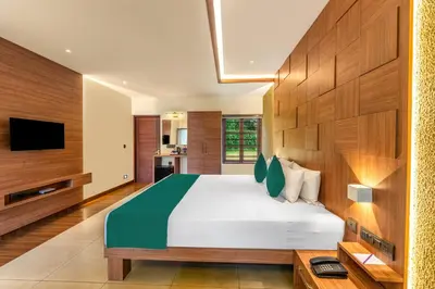 a bedroom with a large bed and a television at Sterling Govardhana Malampuzha in Palakkad