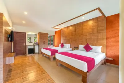 a bedroom with two beds and a kitchen at Sterling Govardhana Malampuzha in Palakkad