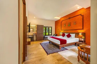a bedroom with a bed and a living room at Sterling Govardhana Malampuzha in Palakkad