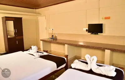 a hotel room with two beds with towels at mangosteen holidays in Vythiri
