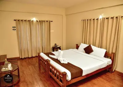 a bedroom with a bed with a white animal on it at mangosteen holidays in Vythiri